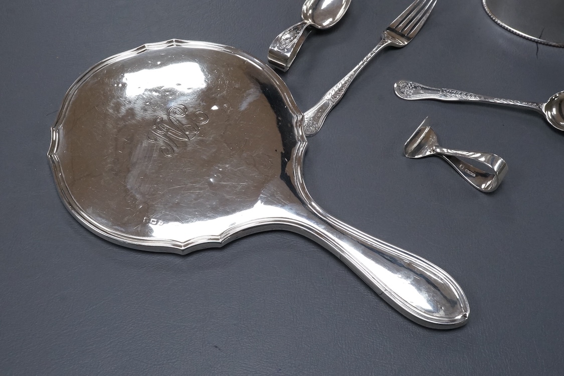A George V silver mounted hand mirror, a silver spoons and pusher, a silver christening fork and spoon and a silver plated tea caddy.